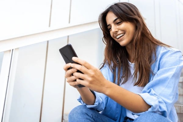 a woman sitting on steps with a cell phone