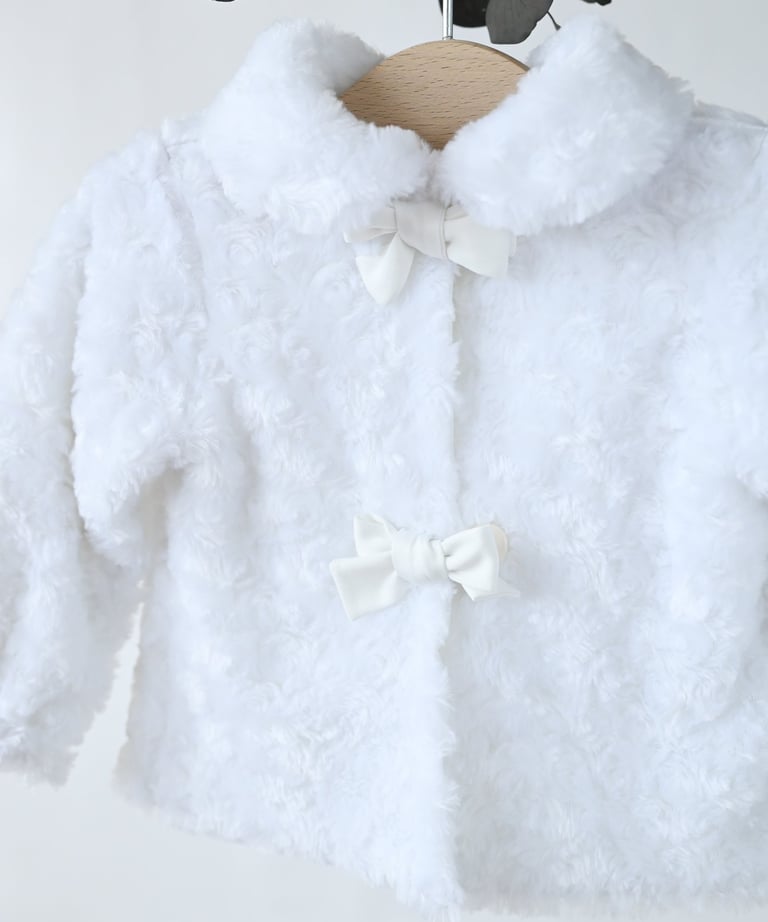 a white fluffy white jacket with a bow tie