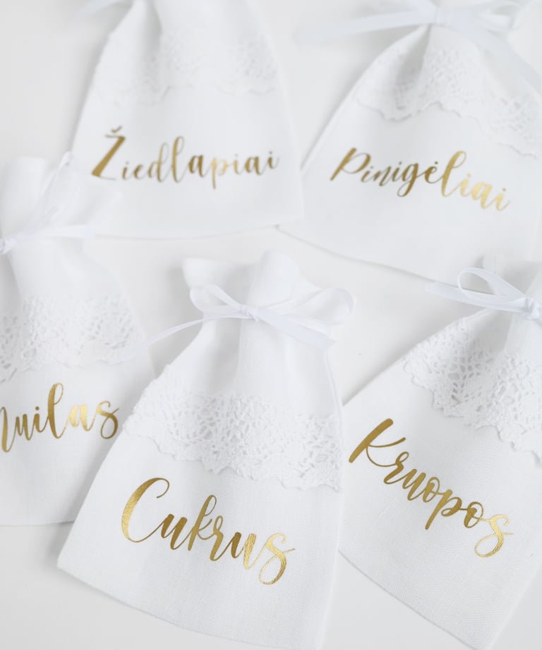 a group of wedding party favors with gold foil and white lace