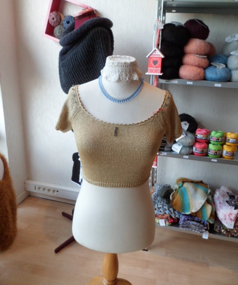 Petit haut demi saison tricoté à la main dans un fil doré avec des finitions au crochet 
