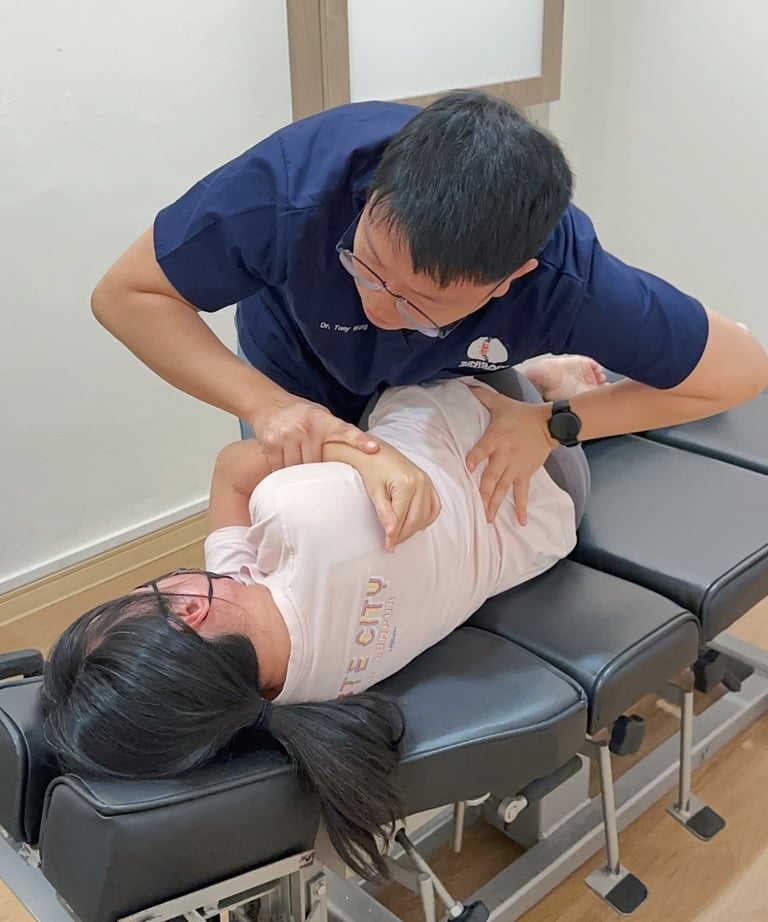  Chiropractor adjusting patient's spine during chiropractic session at Sinisana Chiropractic clinic.