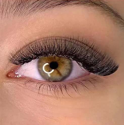 a woman's with volume eyelash extensions eye with a ring on her eye