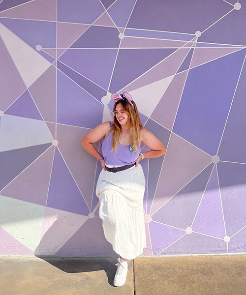 Ameliah Knopp pictured in front of the Purple Wall at Disney's Magic Kingdom® Park.