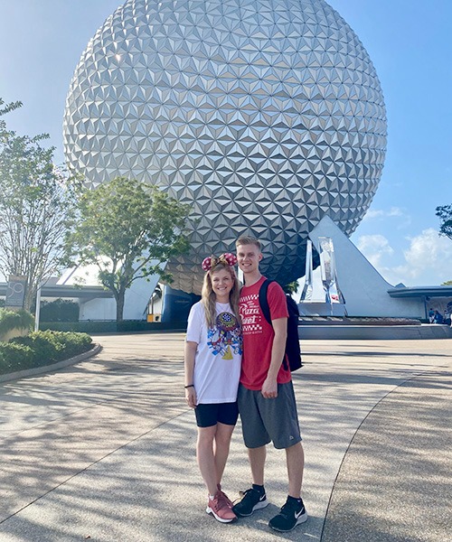 Kasey Kalk pictured with her husband in front of Spaceship Earth at EPCOT®.