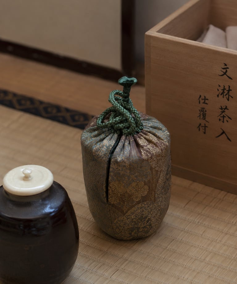 Traditional Japanese tea ceremony tea caddy in a silk brocade shifuku bag on a tatami mat.