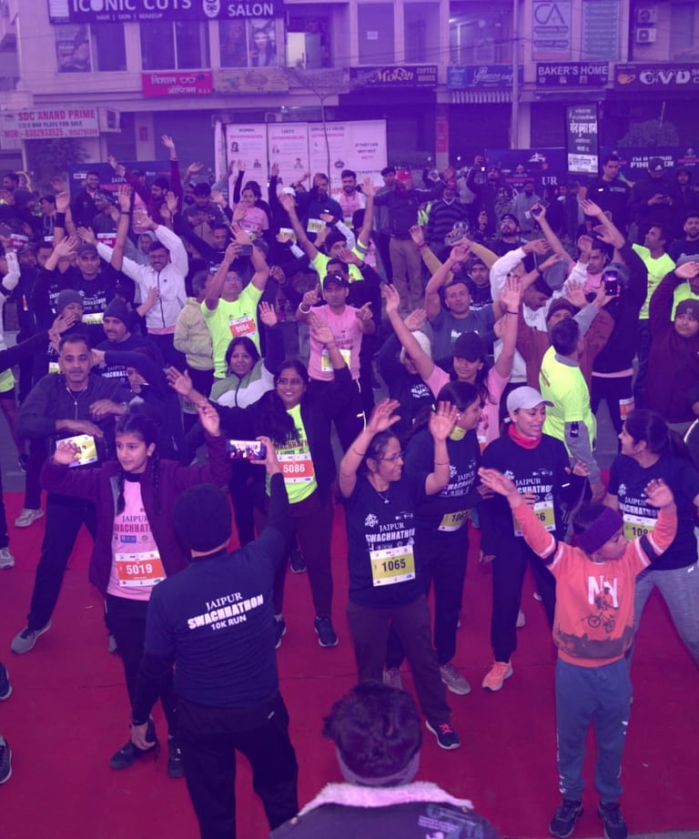 A large group of runners doing warm-up exercises at the Jaipur Ultra 10K run event.