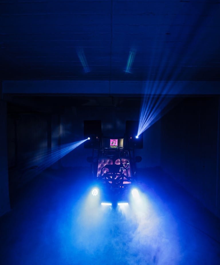 Professional event DJ setup with blue stage lighting and fog machine effects in a dark room.