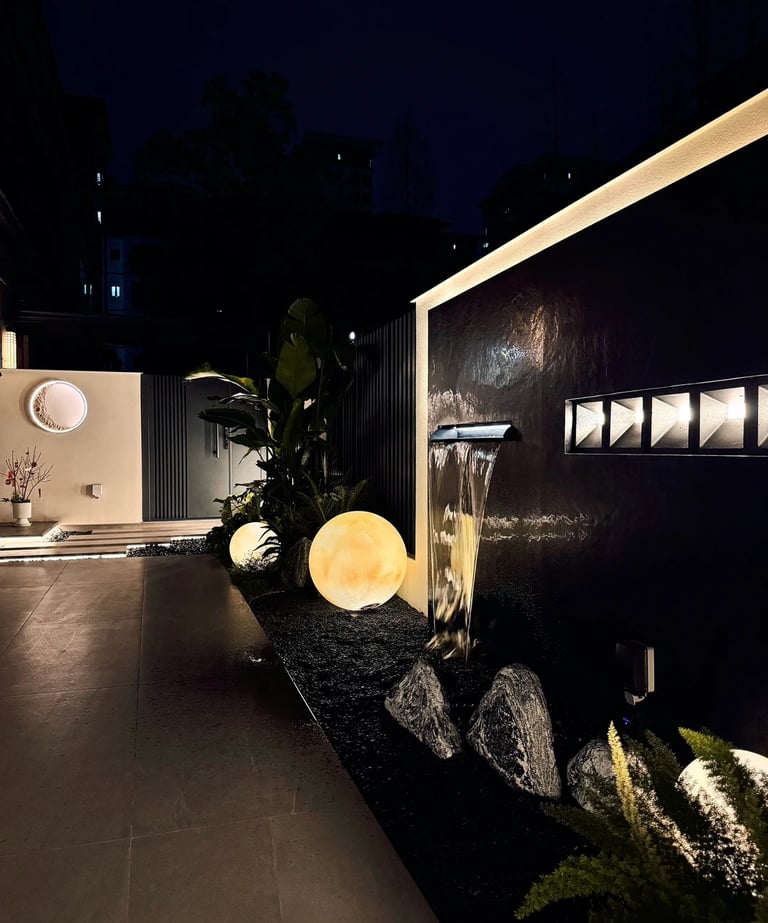 Elegant garden water wall with decorative lighting and natural stone.
