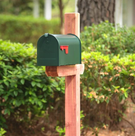 Green mailbox on cedar post