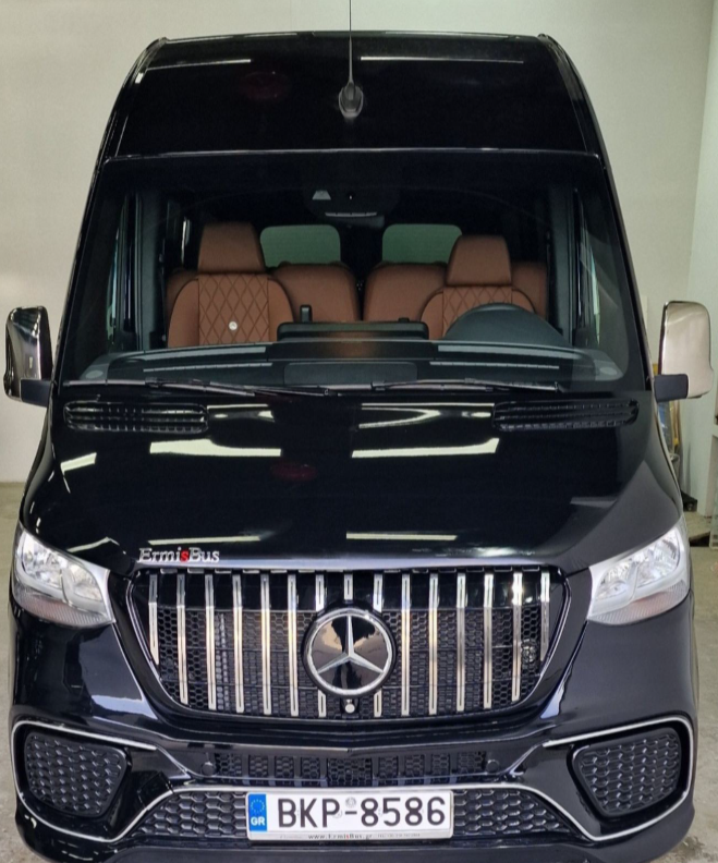 Front view of a luxury black Mercedes-Benz Sprinter passenger van with brown leather seats.