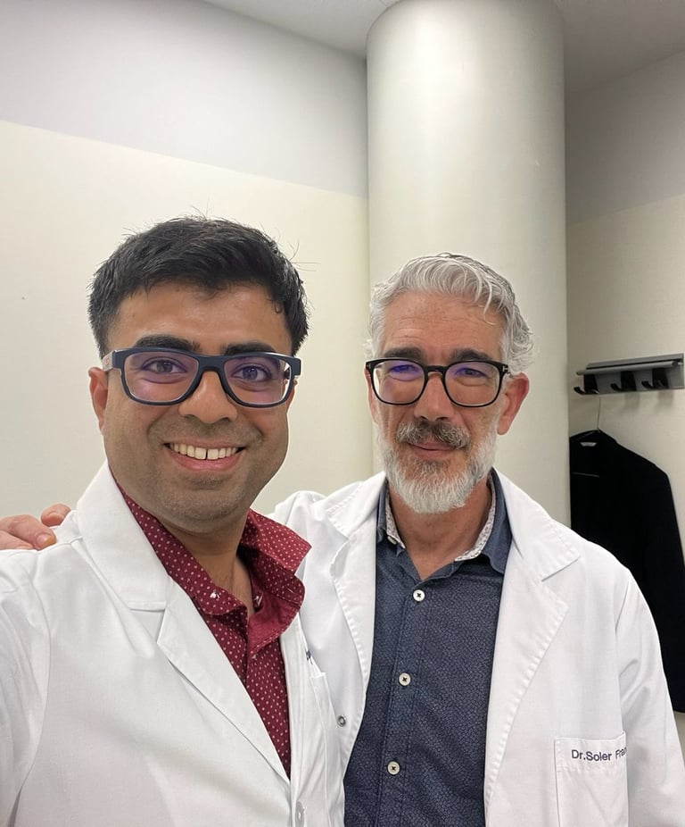 Two smiling male medical doctors in white lab coats posing for a photo in a clinical office.