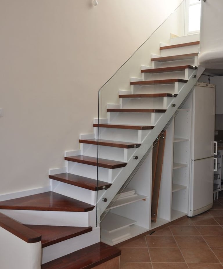 Side-mounted frameless glass stair railing with stainless steel stand-off fixings.