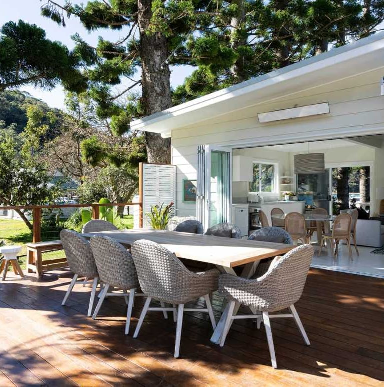 a table with chairs and a table in front of a house