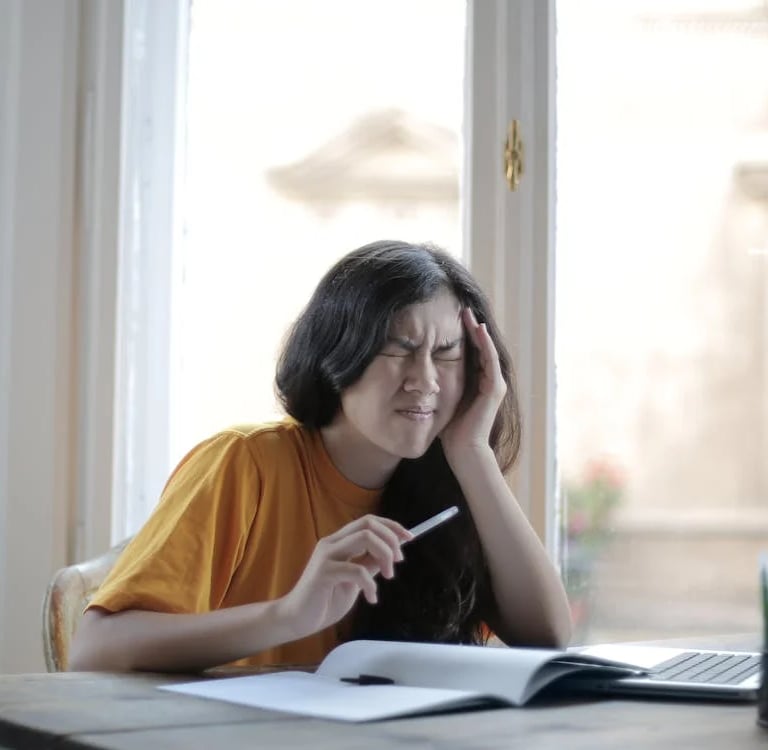 a woman sitting at a desk with a pen and notebook
