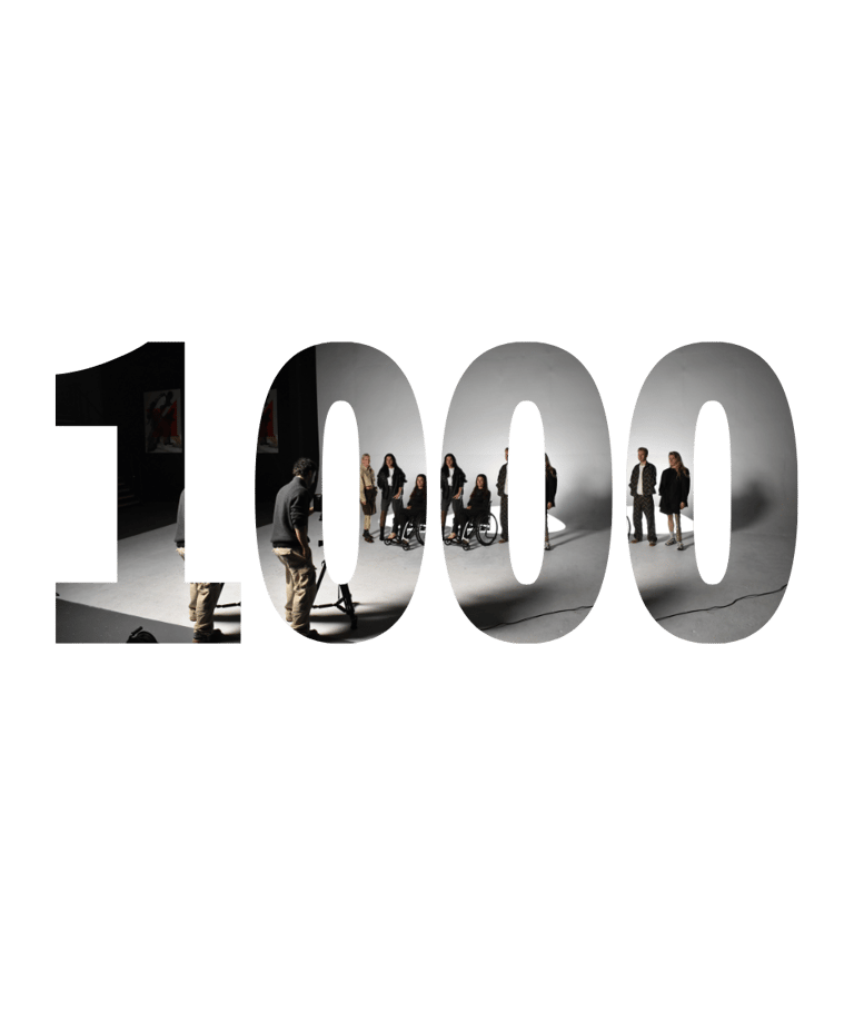 A diverse film crew and actors on a studio set visible through large number 1000 cutout text.