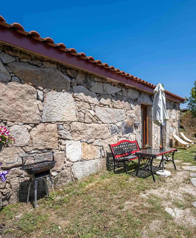 a stone wall with a bench and chairs