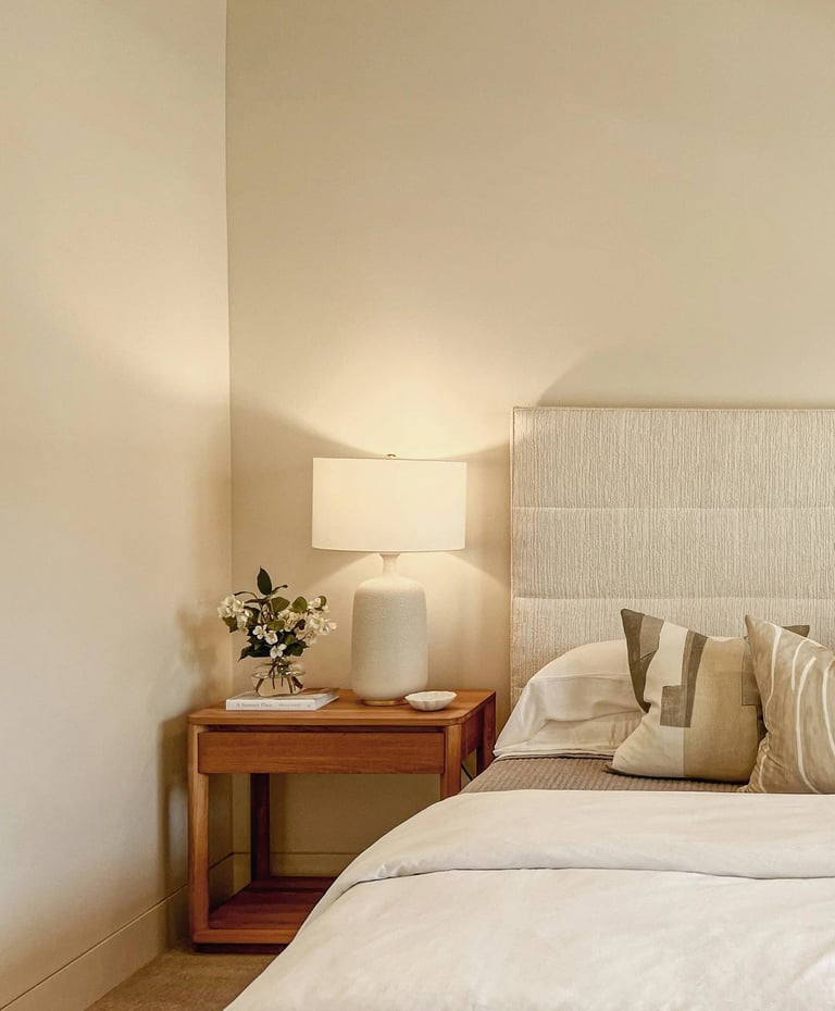 Un lit et une table de nuit avec une harmonie de beiges, pour une ambiance épurée et zen