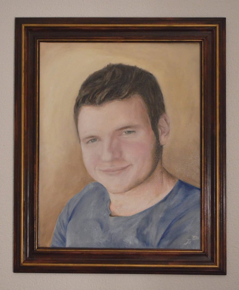 a framed oil painting portrait of a young man in a blue shirt