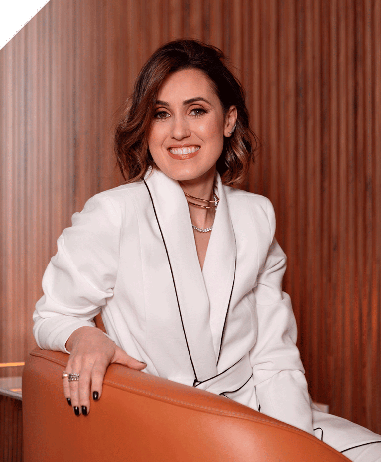 Bruna, mulher com vestes sociais olhando com um sorriso