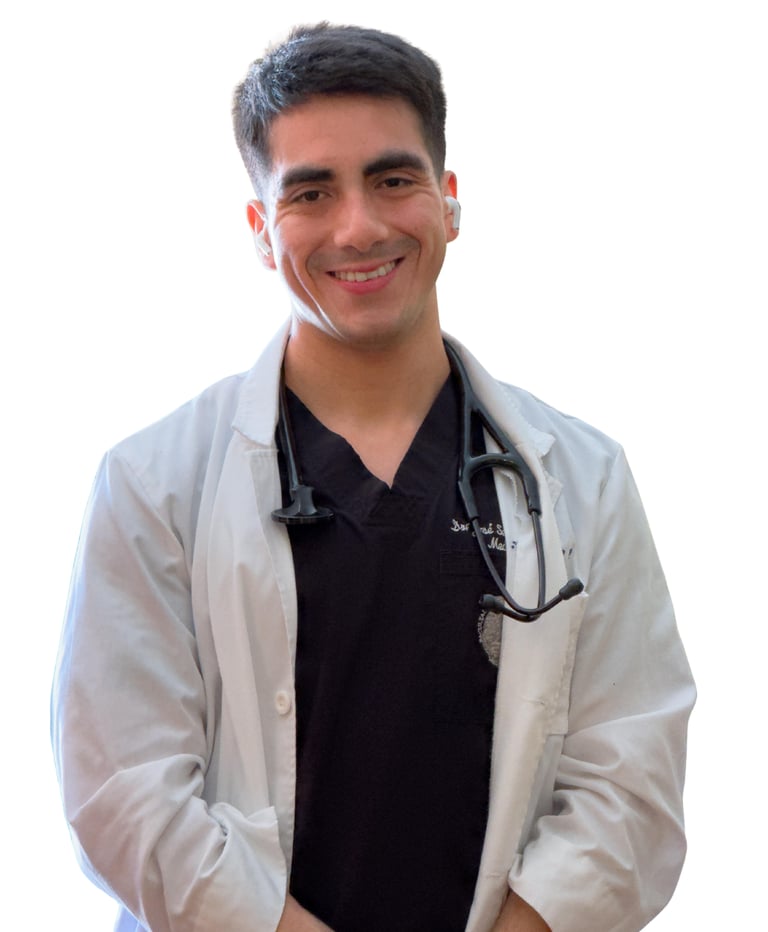 Médico sonriendo con delantal blanco y estetoscopio al cuello.