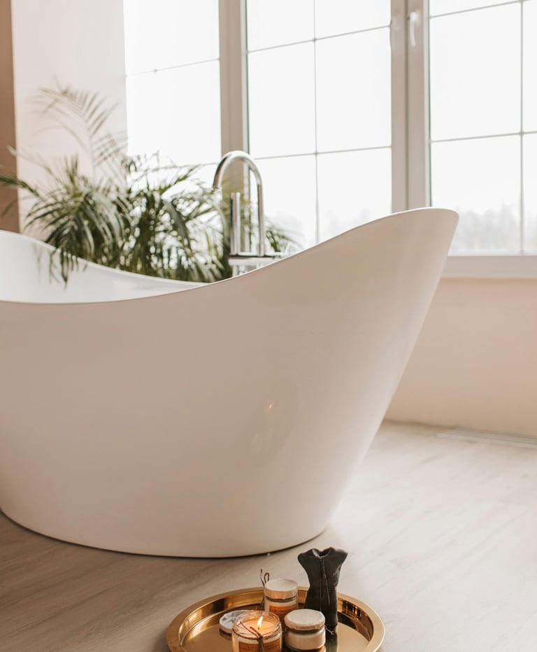 Luxury white bathtub with green fern and large window in background