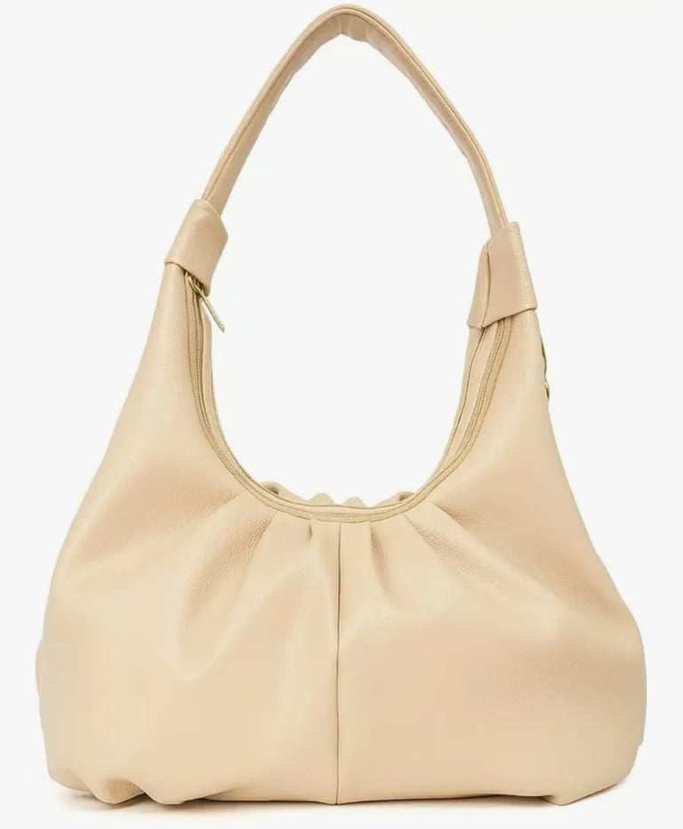 A large beige purse with a large purse on it