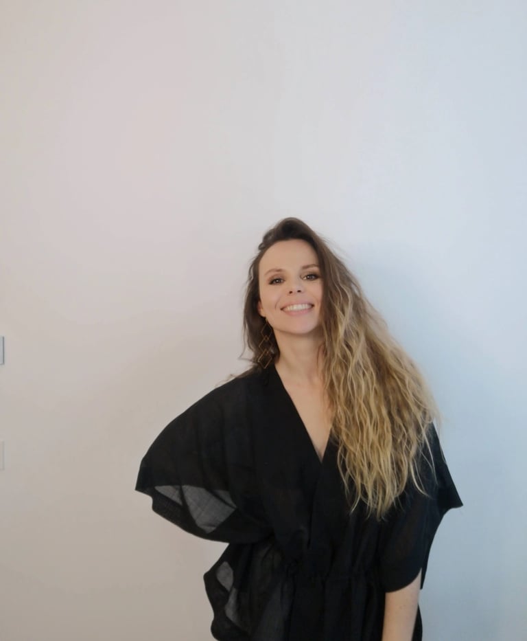 Christine Hauser, RTT Practitioner, smiling warmly in a black kimono top against a white background