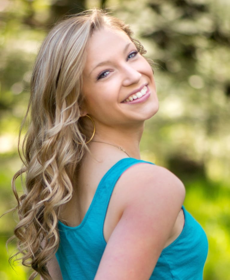 a woman in blue dress smiling and looking at the camera