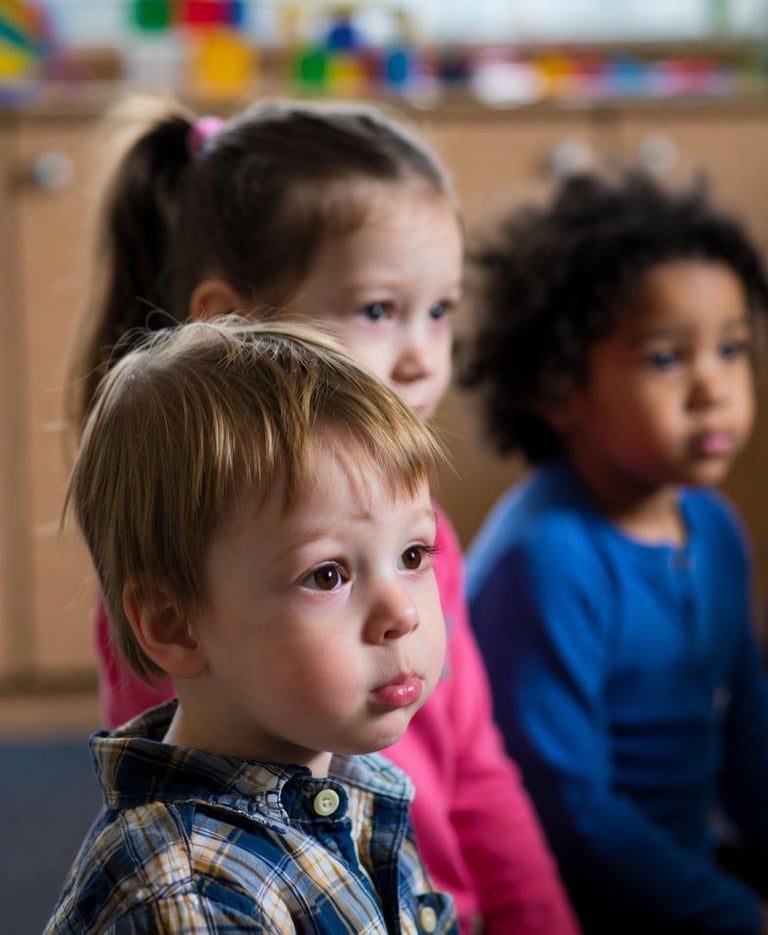 A boy with selective mutism sits with peers for carpet time in a UK nursery.