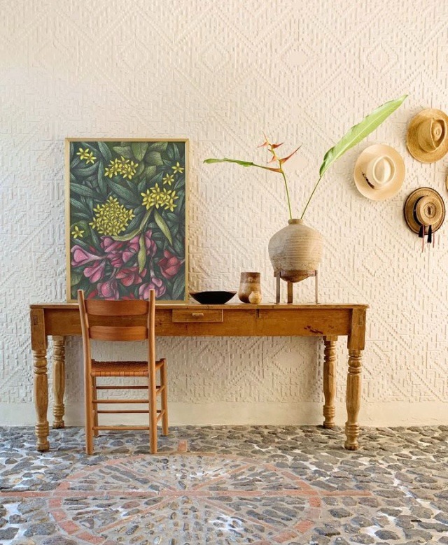 Rustic home interior with a wooden table and a chair and a botanical hand-drawn framed art print