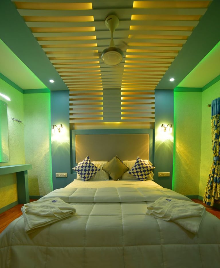 a bed with a white bed and a green wall