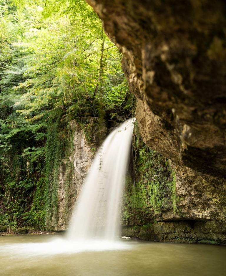 a waterfall in a cave in the woods