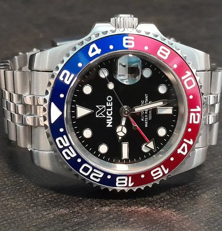 homage nucleo gmt2 master pepsi appoggiato su un piano nero con la corona rivolta in alto