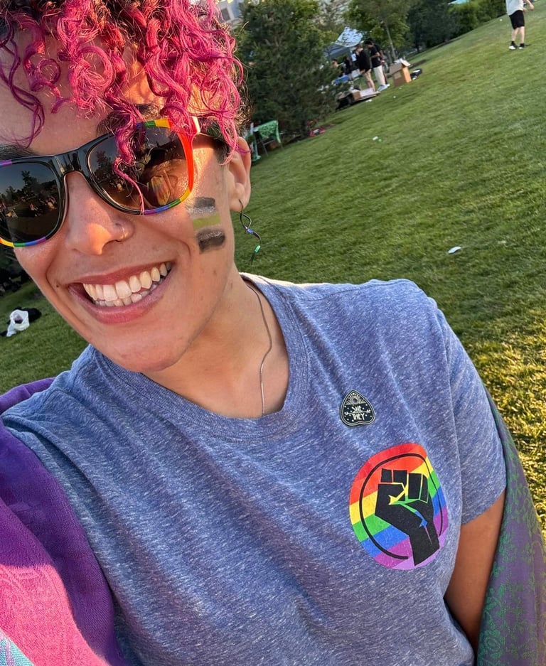 a woman with pink hair and sunglasses on a sunny day
