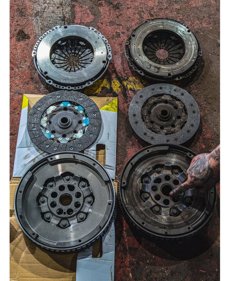 Comparison of new and old car clutch kits including pressure plates, friction discs, and flywheels.