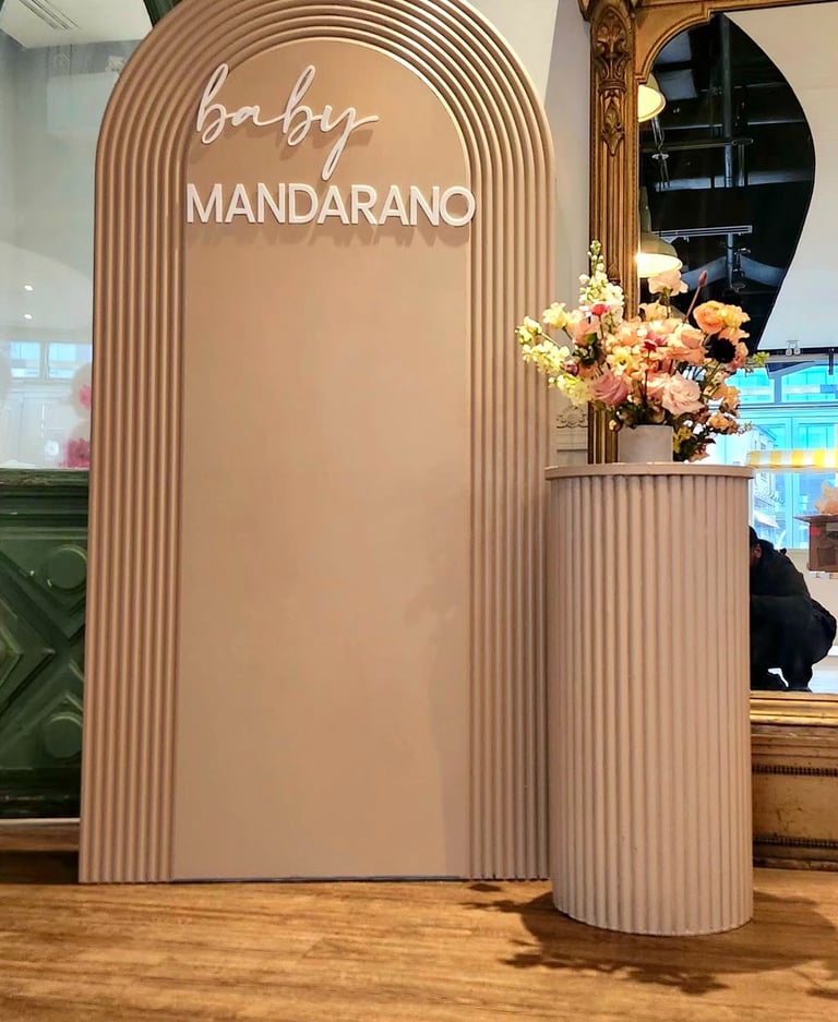 Baby shower with a sign that says, baby mandarino, and a vase with flowers in it