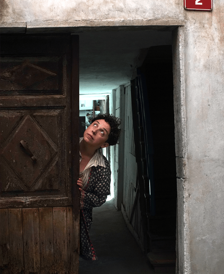 Marisa hiding in an old european doorway, looking up to her right