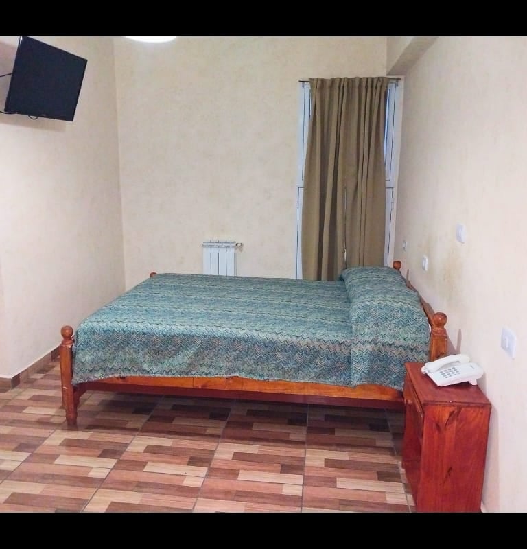 Una habitación con una cama y un televisor