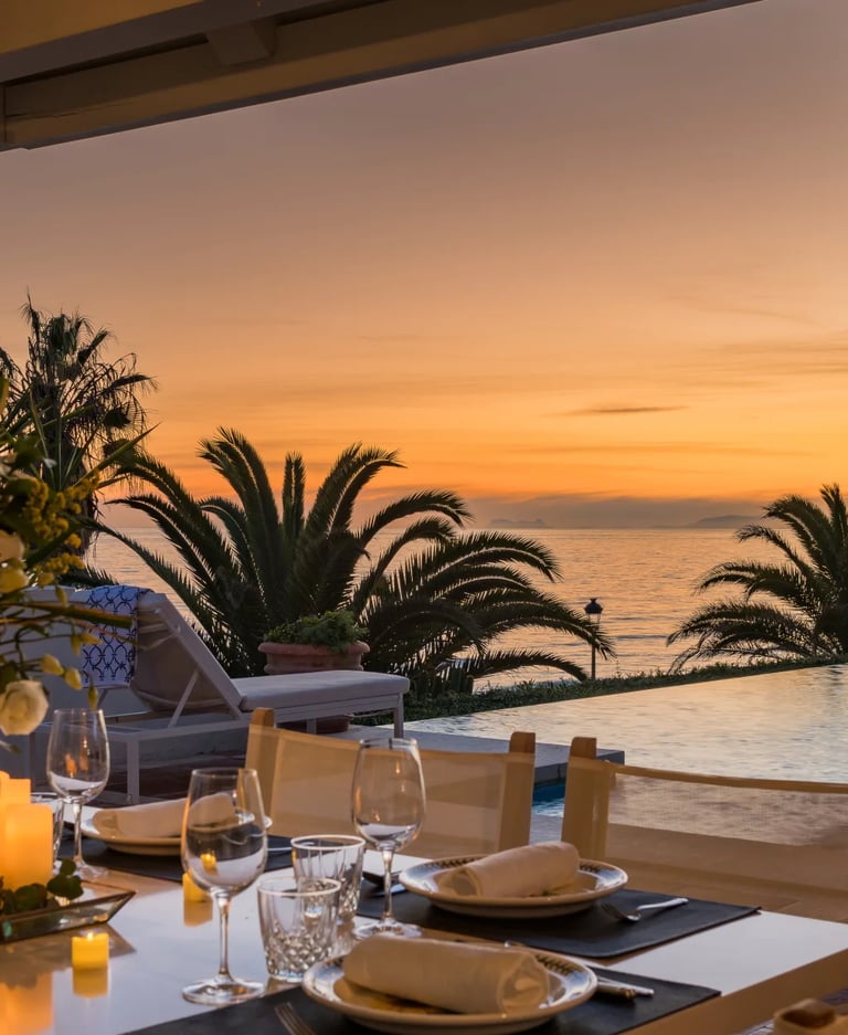 Candlelit dining setting at sunset beside infinity pool and ocean