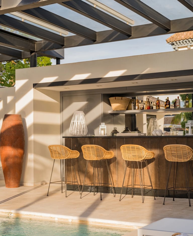 Outdoor bar under pergola with wooden stools
