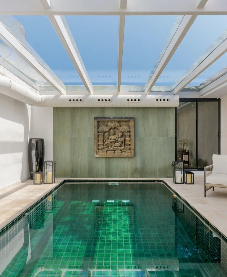 Indoor pool with glass ceiling and lounge area