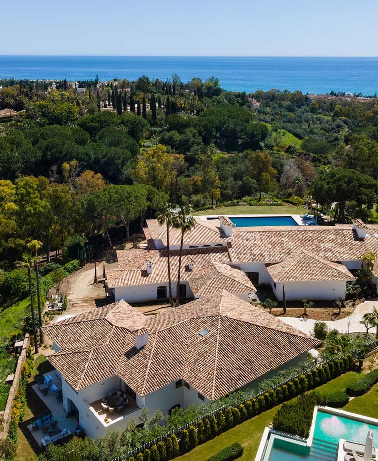 Aerial view of estate with pool, tennis court and sea backdrop