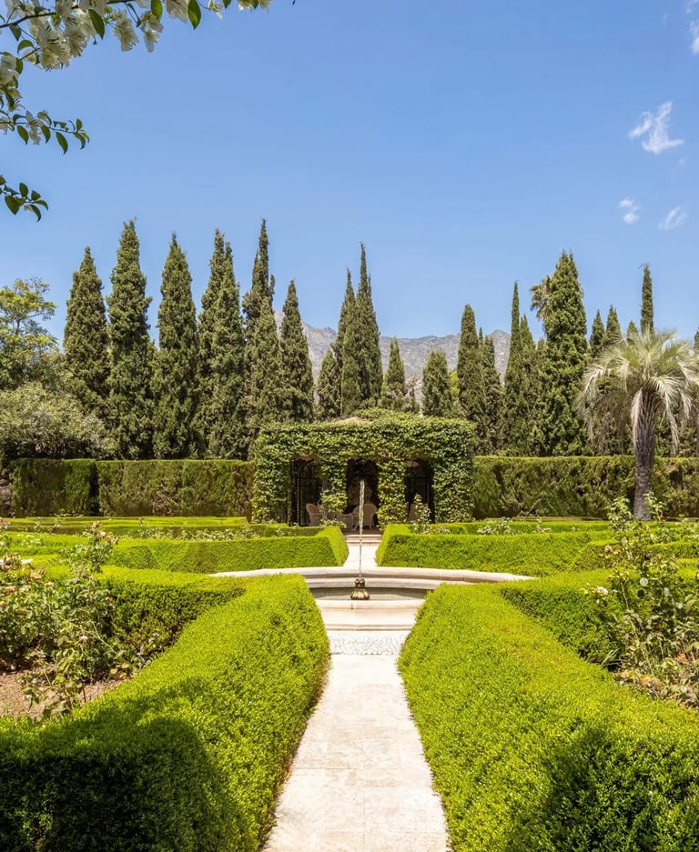 Formal rose garden with clipped hedges and mountain backdrop