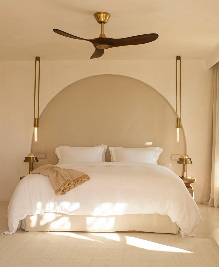 Serene master bedroom with arched headboard and brass lighting
