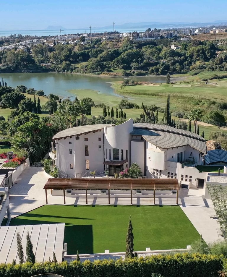 Aerial view of estate with flat lawn and pergola spaces