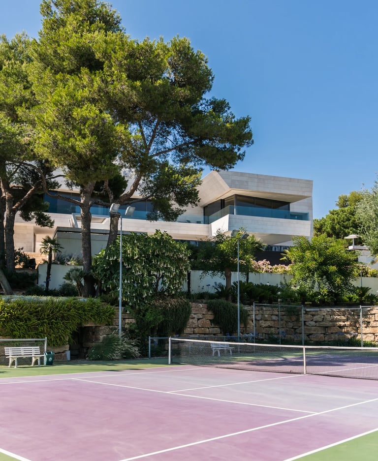 Private tennis court within landscaped gardens