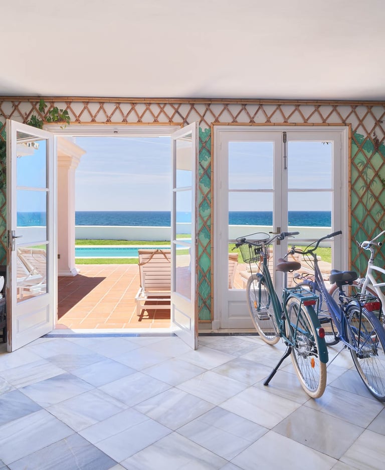 Sea-view lounge with bicycles and open terrace doors