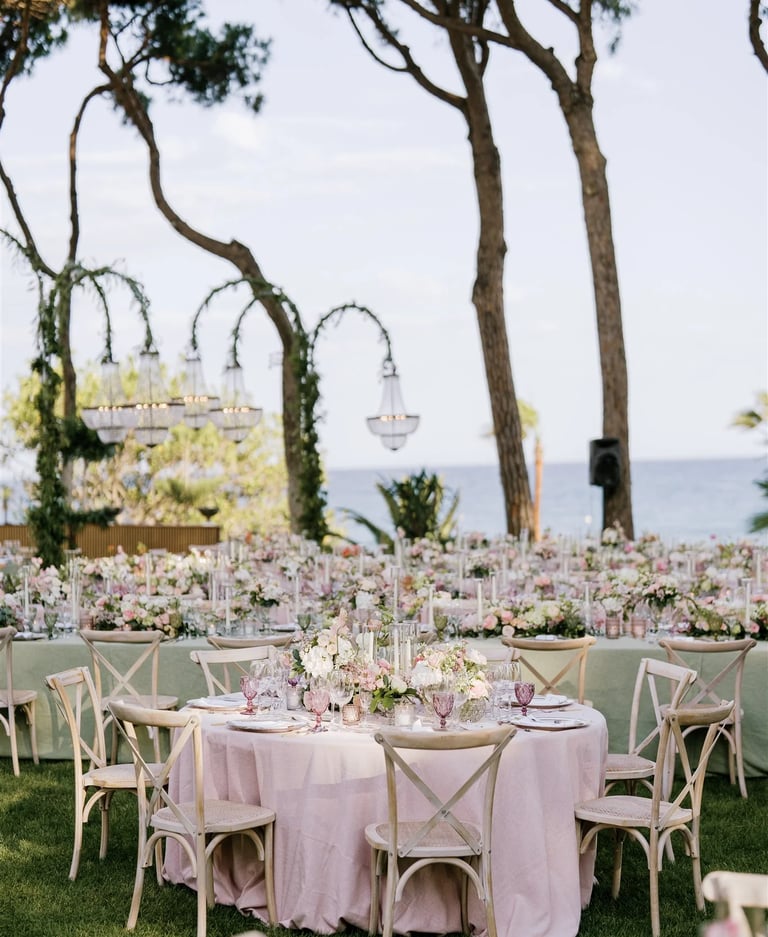 Seafront garden event layout with chandeliers and banquet tables