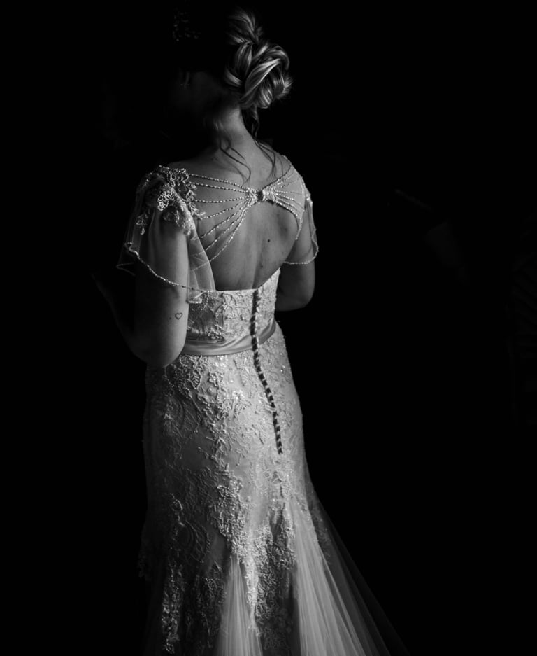 a bride in a wedding dress standing in a black and white photo