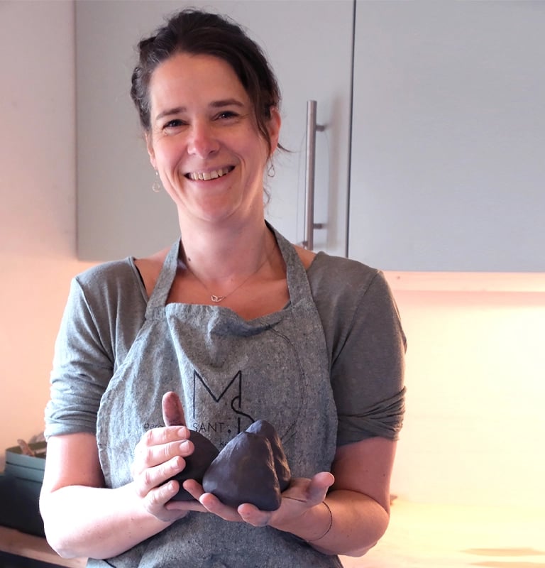 Keramist Maartje met bollen klei in haar handen klaar voor een keramiek cursus in haar atelier in Breda